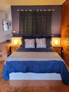 ポリス・デ・アボナにあるLa Chalanaのベッドルーム1室(大型ブルーベッド1台、ランプ2つ付)