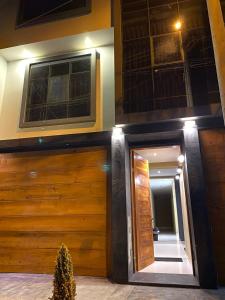 dom z drewnianymi drzwiami garażowymi i lustrem w obiekcie Hotel Alba w mieście Ica