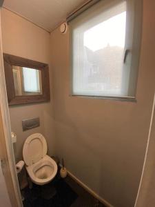 a small bathroom with a toilet and a window at Комфортная квартира Антверпен in Antwerp