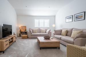 a living room with a couch and a tv at The Lookout in Wells next the Sea