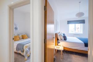 a bedroom with a bed and a window and a door at The Lookout in Wells next the Sea