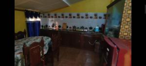 a room with a kitchen with a counter and a table at Old House Villa in Sauraha