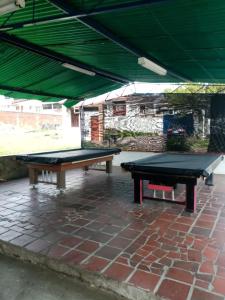 2 mesas de ping pong en un patio de ladrillo en Hotel La Casona, en Chinácota
