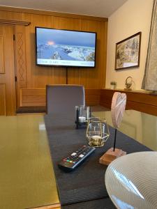 a table with a remote control and a television on a wall at Arlbergsun in Pettneu am Arlberg