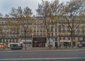 パリにあるSaint Michel Quartier Latinの通りの前に木々が並ぶ大きな建物