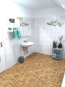 a bathroom with a sink and a white tiled wall at schöne geräumige ganze Wohnung als Unterkunft in Bergen