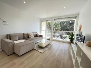 a living room with a couch and a table at Le Chantereine appartement résidentiel in Bourgoin