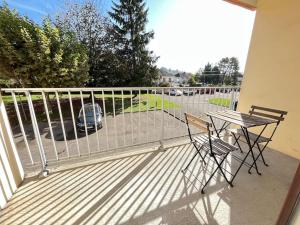a balcony with a table and chairs and a fence at Le Chantereine appartement résidentiel in Bourgoin