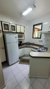 a kitchen with a white refrigerator and a window at Riviera Green Apartamento 114 in Riviera de São Lourenço