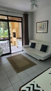 a living room with a couch in the middle of a room at Riviera Green Apartamento 114 in Riviera de São Lourenço