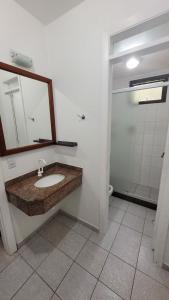 a bathroom with a sink and a mirror and a shower at Riviera Green Apartamento 114 in Riviera de São Lourenço