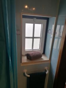 - un miroir dans la salle de bains avec une fenêtre et une serviette dans l'établissement A casinha do Pescador, à Nazaré