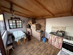 a kitchen with a table and a brick oven at Casa de vacanta Mirela in Novaci-Străini