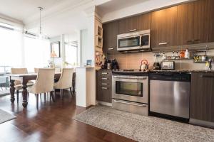 a kitchen with stainless steel appliances and a table at Stunning condo with fantastic view of the city! in Toronto