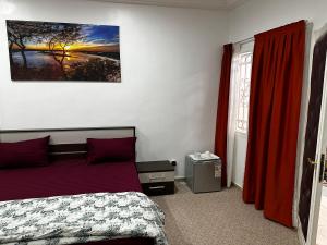 1 dormitorio con cama y cortina roja en Chambres d'hôte centre ville en Dakar