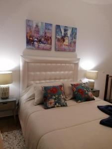 Ce lit se trouve dans un dortoir orné de 2 peintures murales. dans l'établissement A casinha do Pescador, à Nazaré