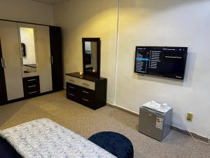 una camera con letto, TV e specchio di Chambres d'hôte centre ville a Dakar