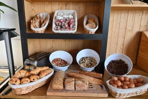 une table avec différents types de pain et autres denrées alimentaires dans l'établissement Le Catalan, à Banyuls-sur-Mer