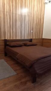 1 cama en un dormitorio con pared de madera en Міні готель на Костюринському, en Járkov