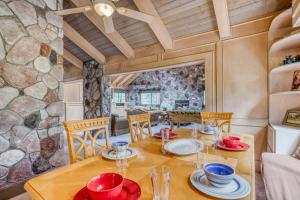 een eetkamer met een tafel en stoelen en een stenen muur bij 036 - Eye of the Eagle in Big Bear Lake