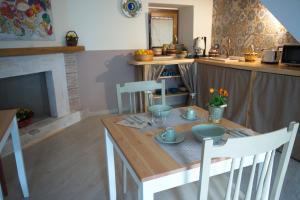 a kitchen with a wooden table and a table and chairs at Dimora Offidius in LʼAquila