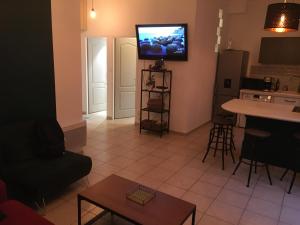 een woonkamer met een keuken en een televisie aan de muur bij Terrasses du Port 5 mn, T2 moderne tout équipé 5 couchages in Marseille