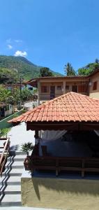 a house with a tile roof and a patio at Pousada Sakura Rio Mar in Abraão