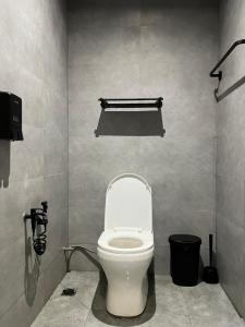 a bathroom with a white toilet in a stall at ZUSCH STUDIO in Pantai Cenang