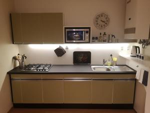 uma cozinha com um fogão, um lavatório e um relógio em Das Kleine Haus - Vintage-Apartment im Innenhof em Viena