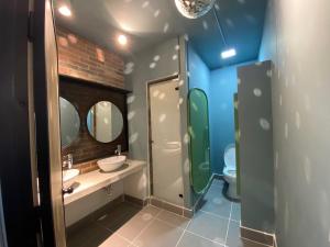 a bathroom with a sink and a toilet and two mirrors at 103 Wonderful House in Bogotá