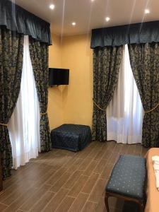 una sala d'attesa con tende, divano e TV di la casa di romi a Catania