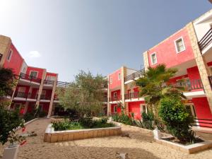 eine Reihe von Gebäuden mit Palmen im Innenhof in der Unterkunft Estoril Hotel - Apartments in Sal Rei