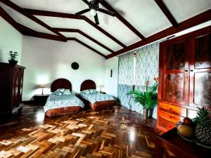 a bedroom with two beds and a wooden floor at Canal Grande Lodge in Piedades