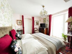a bedroom with a large bed with red curtains at Domaine de Praterou in Roscoff