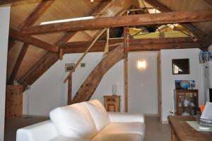 una sala de estar con un sofá blanco y techos de madera. en Attika Wohnung 7546 Ardez en Ardez