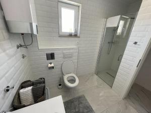 a white bathroom with a toilet and a shower at Island Brac - Villa Vita in Nerežišće +23 photos