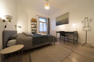 1 dormitorio con cama, escritorio y mesa en AppartUnique - Chez Klein, en Vichy