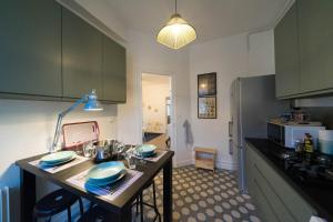 uma cozinha com armários verdes e uma mesa com cadeiras em AppartUnique - Chez Klein em Vichy