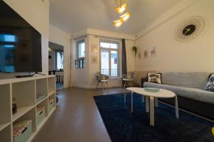 ein Wohnzimmer mit einem Sofa und einem Tisch in der Unterkunft AppartUnique - Chez Klein in Vichy