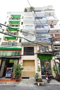 a tall white building with plants in front of it at Huyen Homestay in Ho Chi Minh City