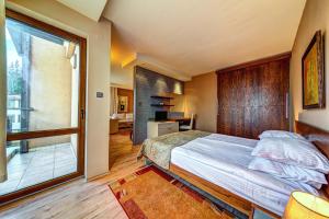 a bedroom with a large bed and a large window at Апартаменти Свети Трифон in Pamporovo