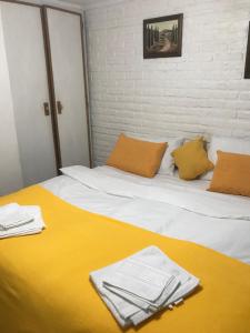 1 dormitorio con 1 cama grande con manta amarilla en Studio en PH La casita de Pablo en Buenos Aires