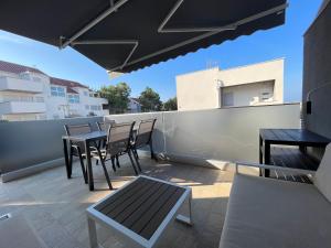 a patio with tables and chairs on a balcony at Apartment Lucija in Šimuni