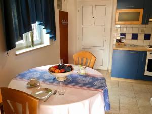 a kitchen with a table with a bowl of fruit on it at Apartments Villa Jadranka Adults only in Bol
