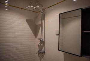 a shower with a mirror in a bathroom at Classic Hotel in AlUla