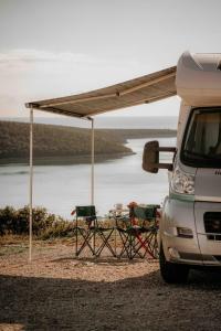 Camper for 4 persons Istria في بولا: طاولة وكراسي تحت خيمة بجوار فان