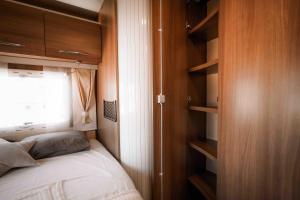 a small bedroom with a bed and a window at Camper for 4 persons Istria in Pula