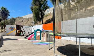 um parque infantil com um escorrega e um equipamento de brincar em Departamento Cantiles Dorados em Raulis