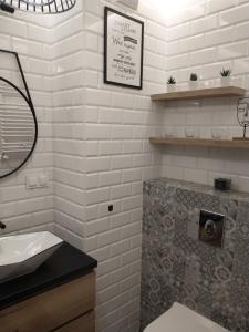 W białej łazience znajduje się umywalka i lustro. w obiekcie AGAR HOUSE Reymonta w mieście Łomża