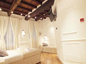 1 dormitorio con 2 camas y TV en la pared en Domus Ester, en Roma